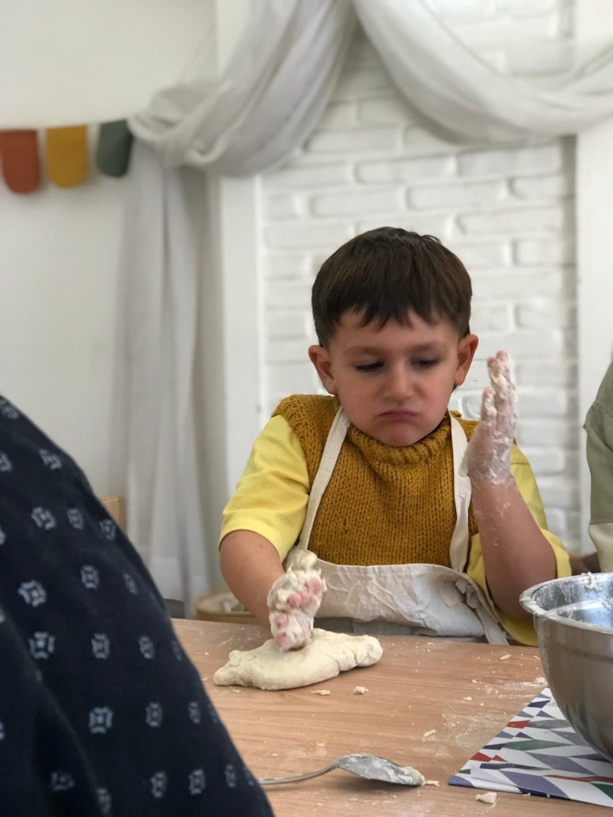 Un nene amasando en la cocina del jardín